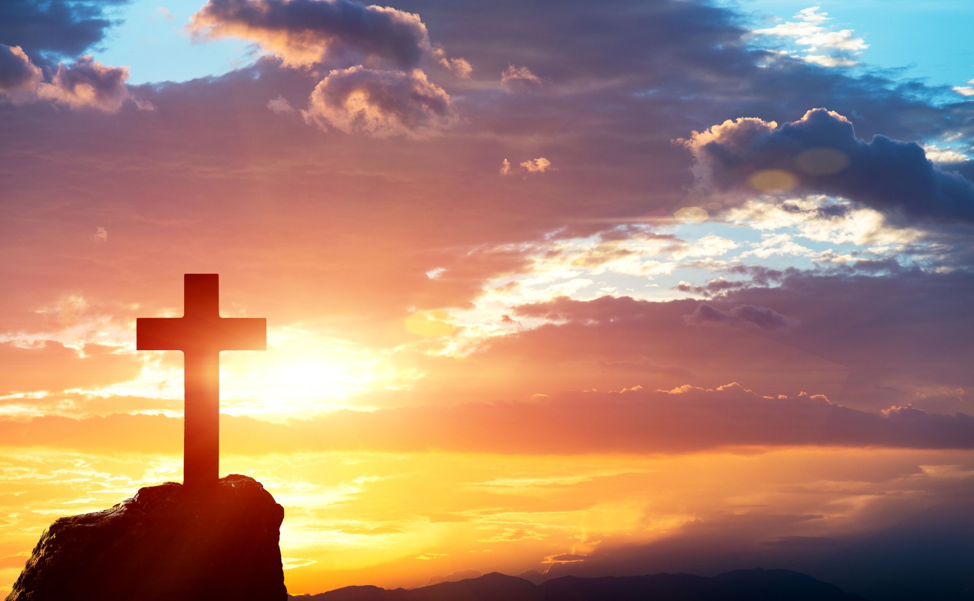 Religious cross on the hill at sunset